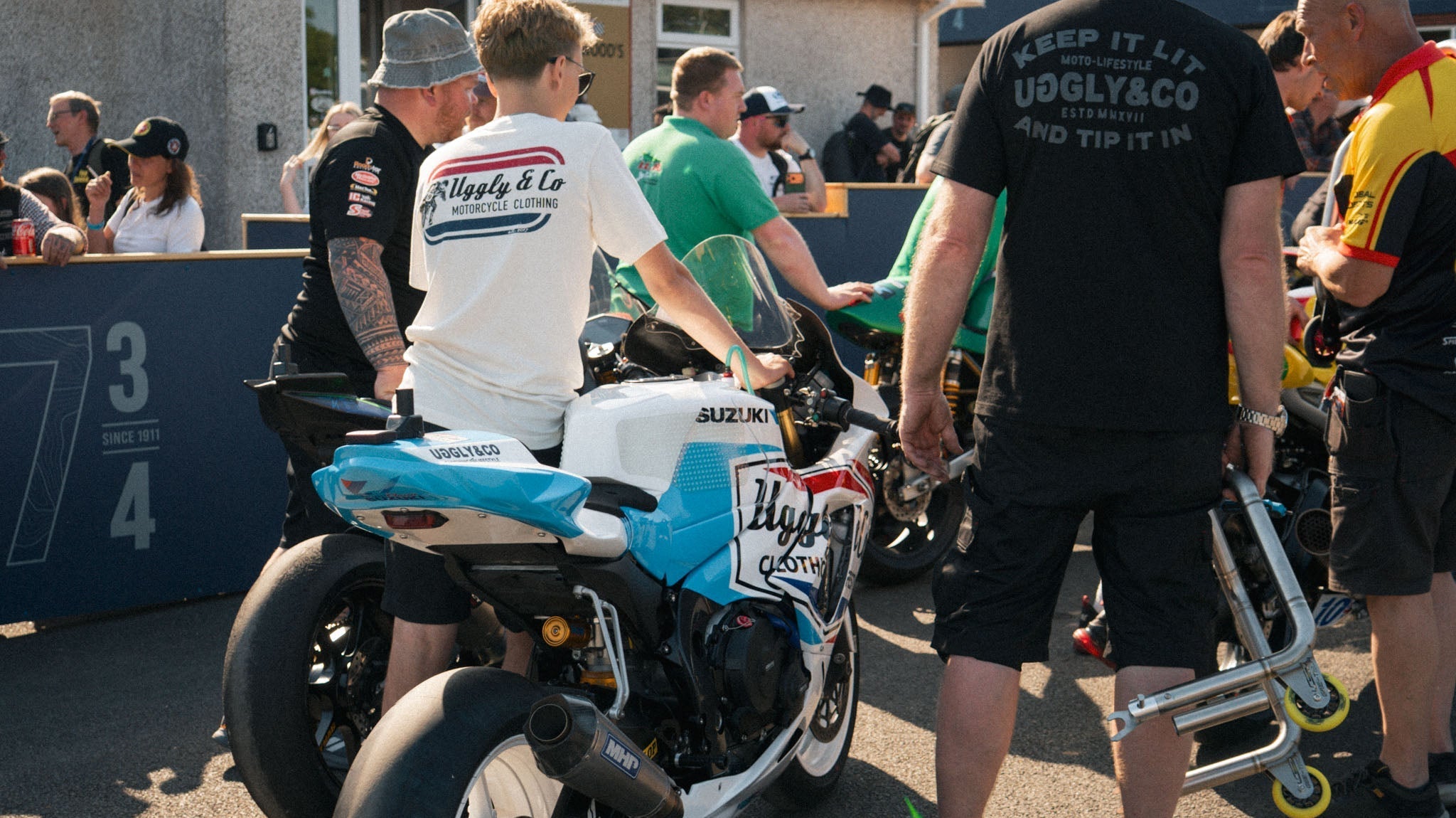 race mechanics walking bike up to inspection at Isle of Man tt