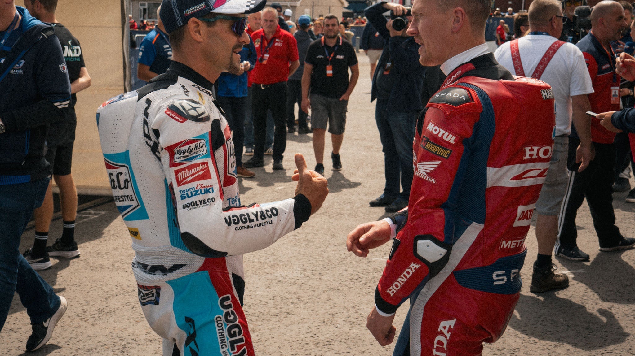 dean Harrison and josh brookes talkling in busy paddock at race event