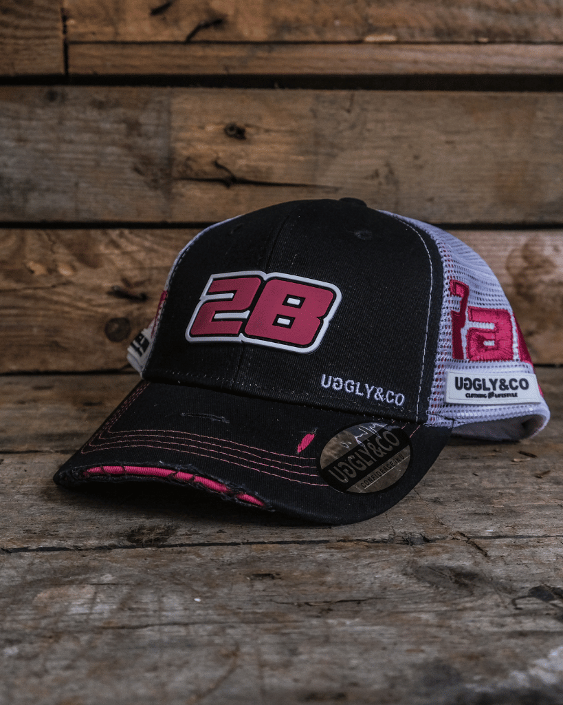 Black and white trucker hat with red number 28 on a wooden background