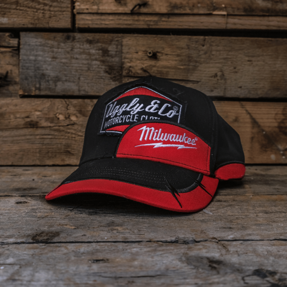 Black and red cap with logos on a wooden surface