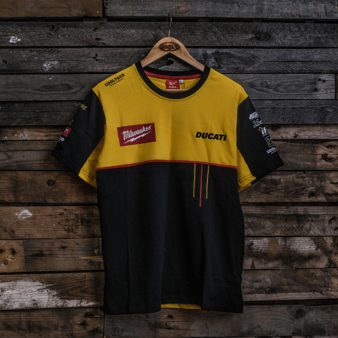 Yellow and black shirt with Ducati and Milwaukee logos on a wooden background