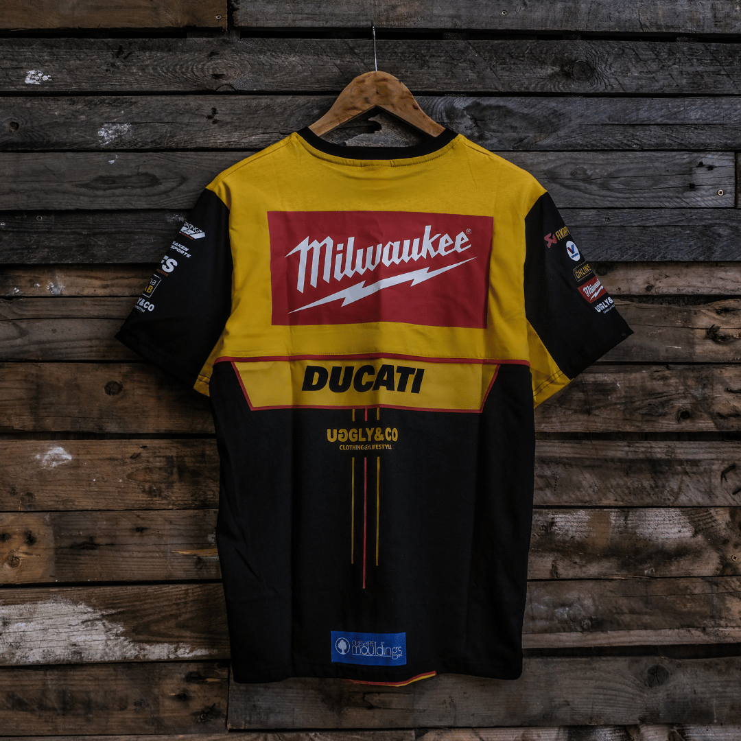 Yellow and black shirt with Milwaukee and Ducati logos on a wooden background