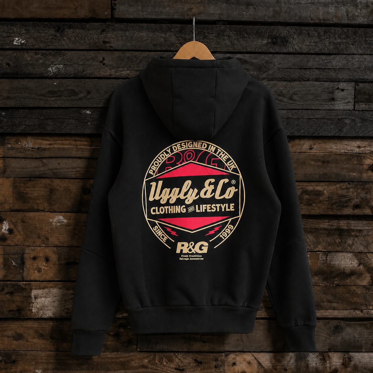 A black pullover hoodie hanging on a wooden hanger against a dark rustic wood plank wall. The back of the hoodie features a large circular graphic print with the text 'Uply & Co CLOTHING & LIFESTYLE' and 'P&G' branding.