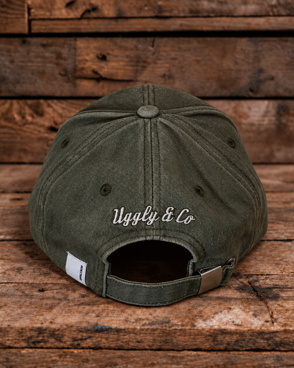 product photo showing the back logo on green baseball cap on a wood background