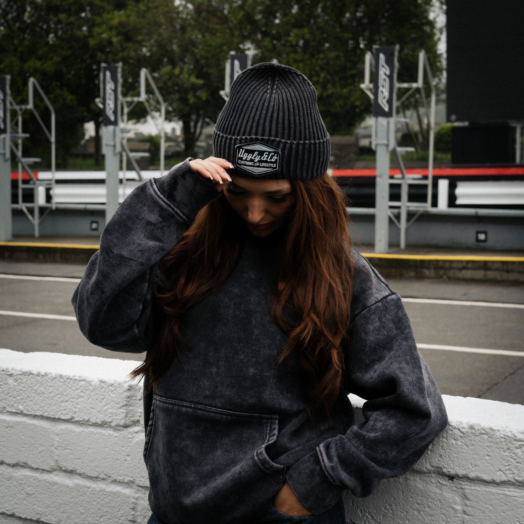 Girl model wearing a black Diamond beanie while standing in the pit lane