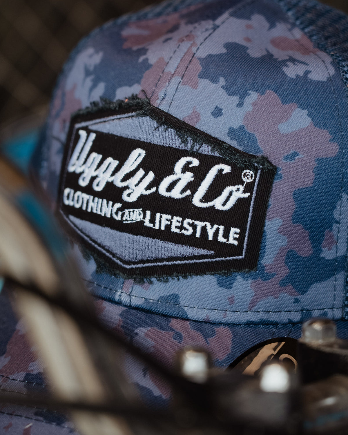 Blue camouflage trucker cap featuring Uggly & Co diamond branding
