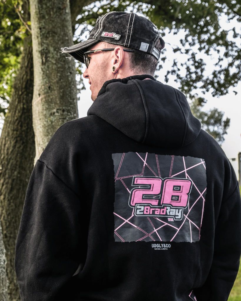 Brad Ray, BSB Racer wearing a black hoodie with a pink and white design on the back, standing outdoors.