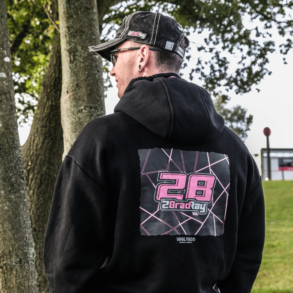 Brad Ray, BSB Racer wearing a black hoodie with a pink and white design on the back, standing outdoors.
