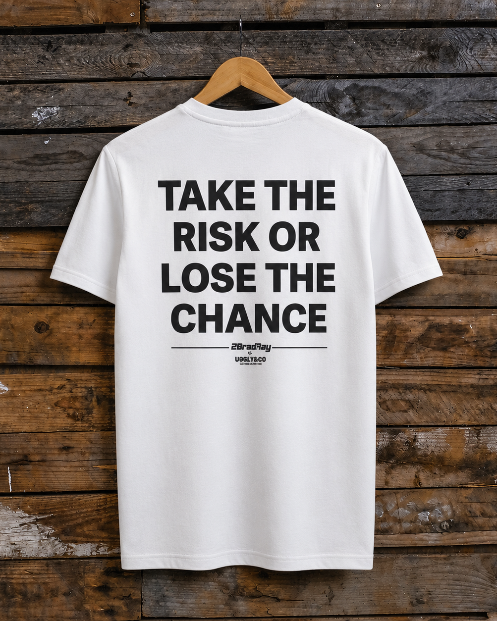 Rear view of a Bradley Ray signature take the risk white t-shirt on a wooden background