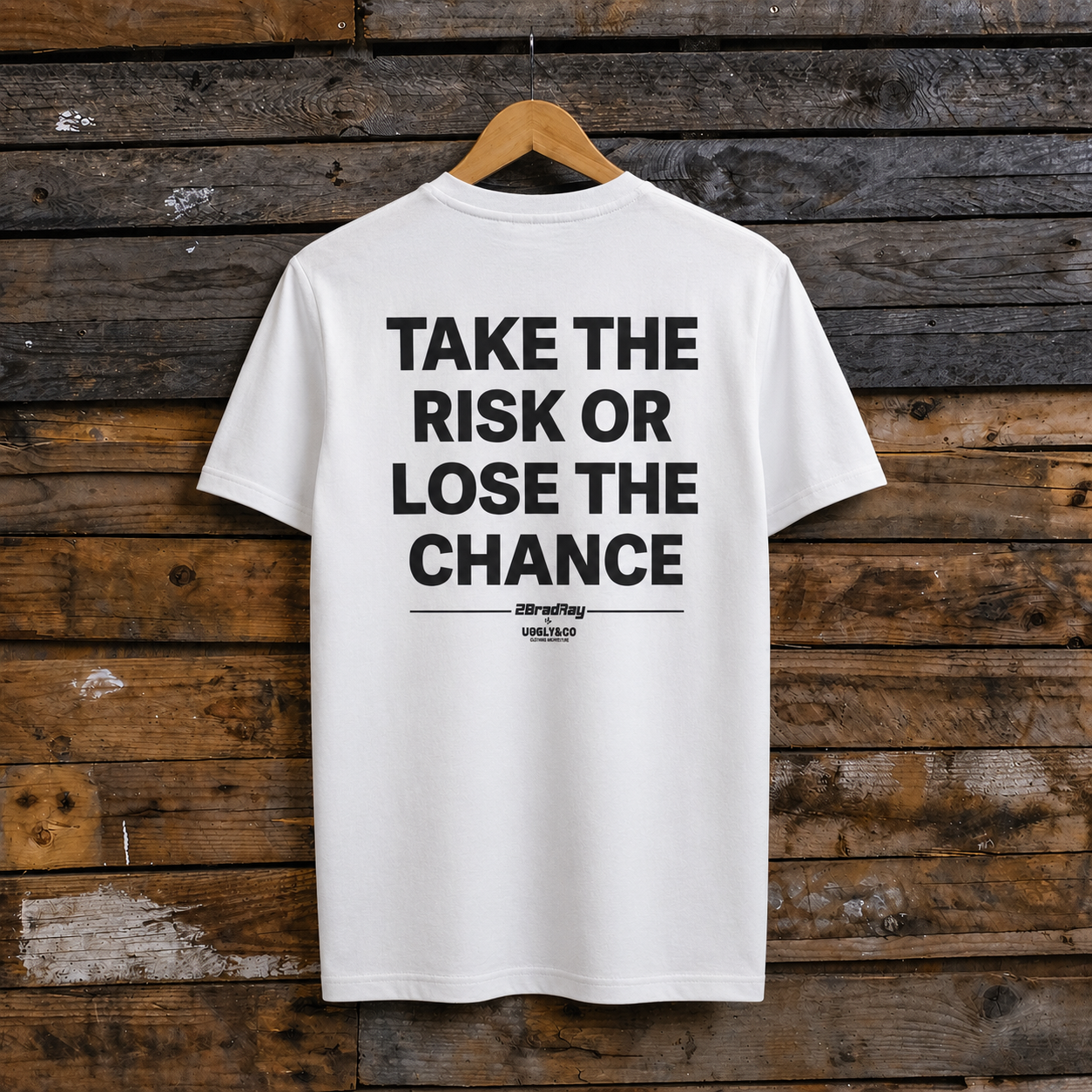 Rear view of a Bradley Ray signature take the risk white t-shirt on a wooden background