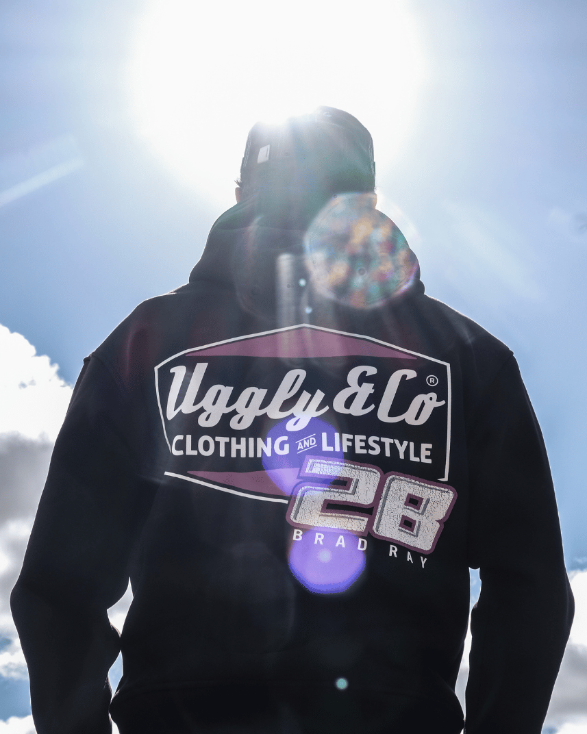 Rear view of a model wearing a black hoodie with a Uggly&Co and Bradley Ray inspired Brad Ray 28 logo