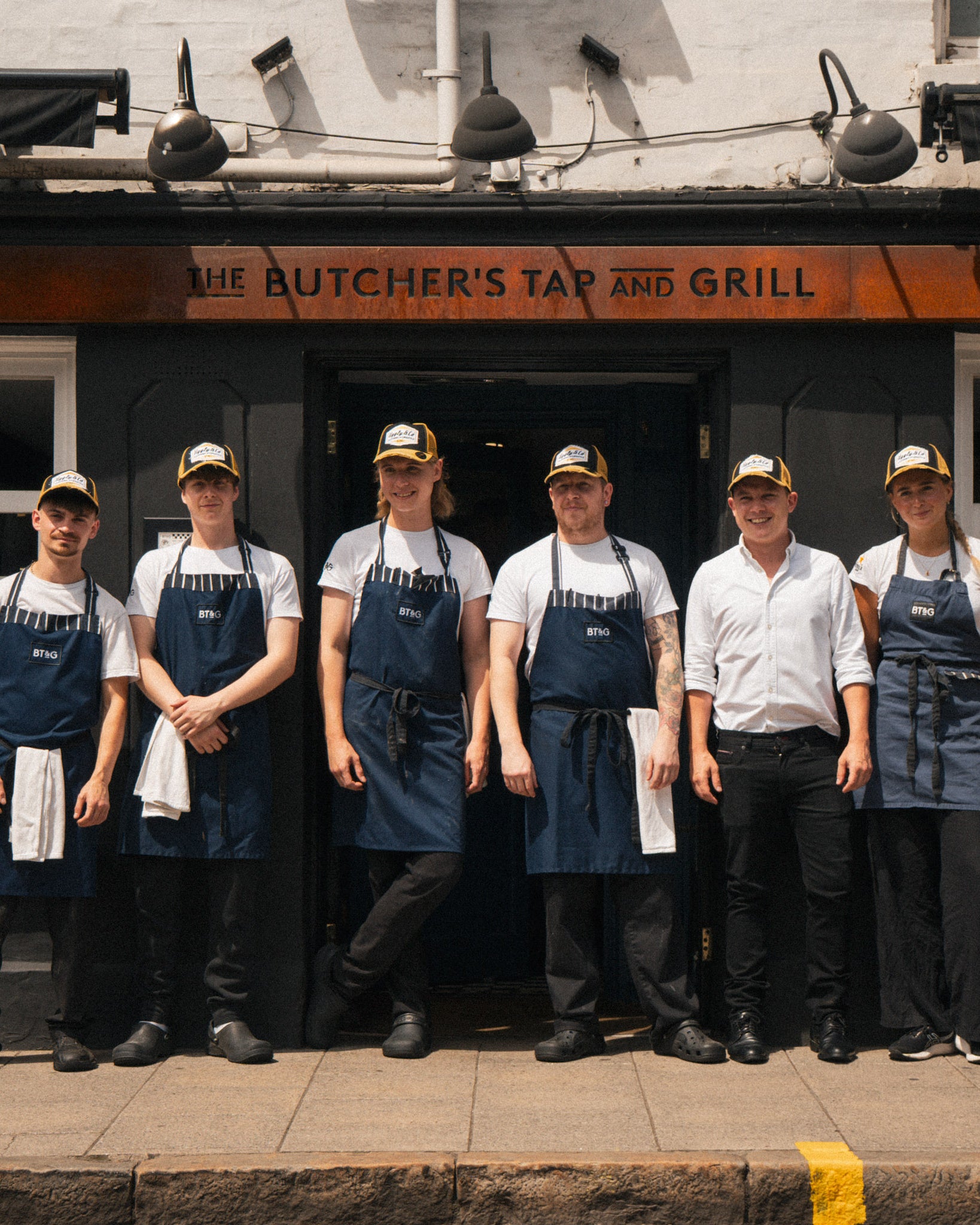Butchers Tap restaurant staff wearing branded caps