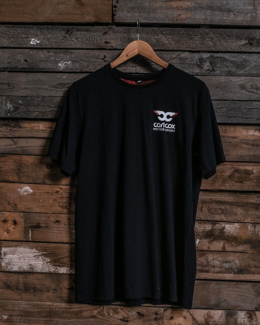 Front view of a Carl Cox Motorsport BPM RPM black t-shirt on a wooden background