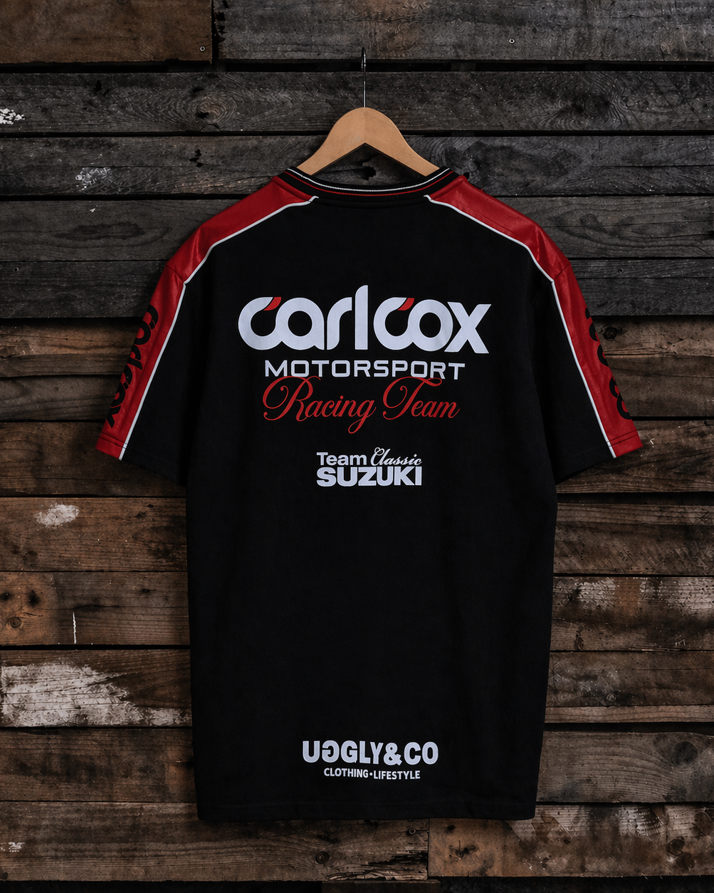 Rear view of a Carl Cox motorsport and Team Classic Suzuki black and red t-shirt on a wood background