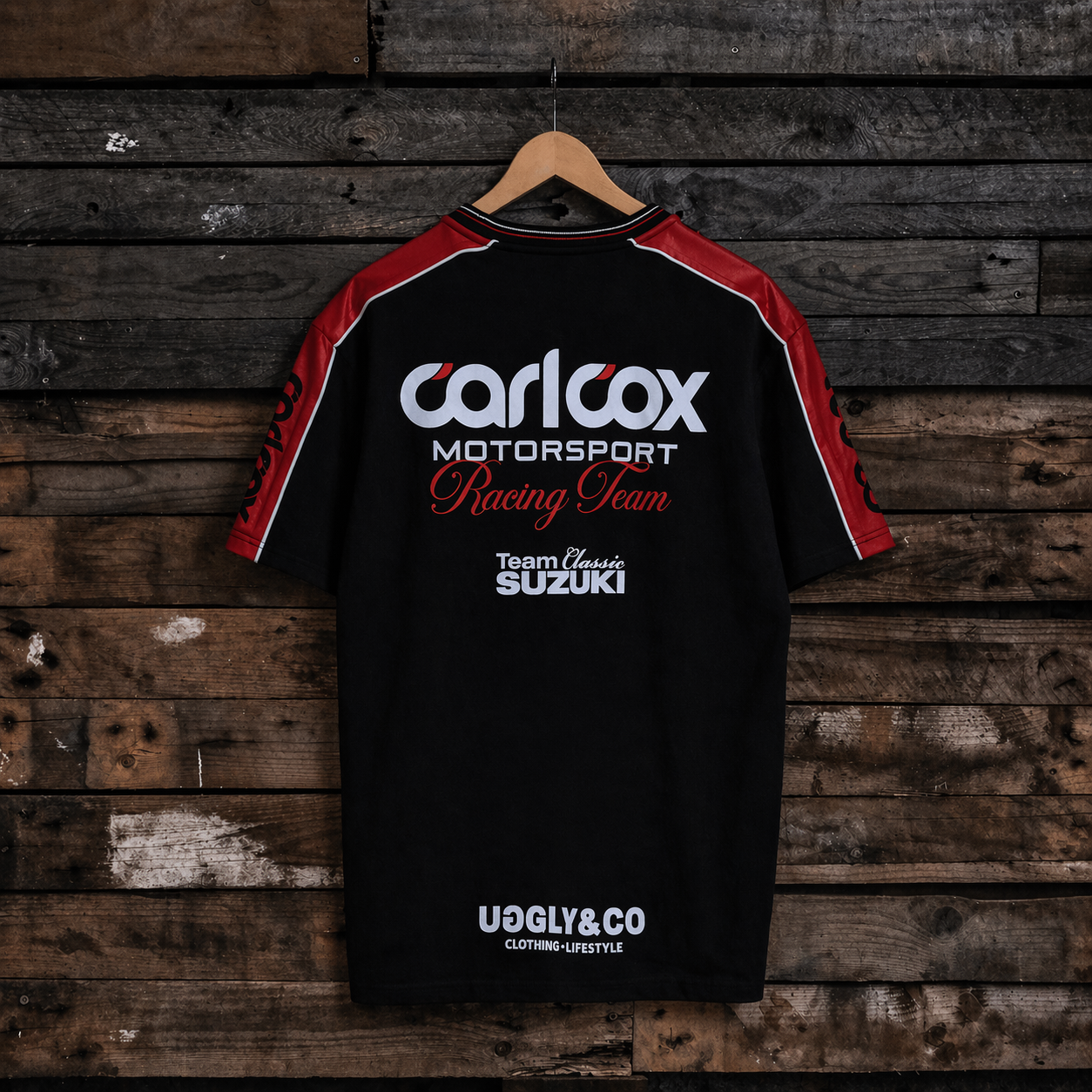 Rear view of a Carl Cox motorsport and Team Classic Suzuki black and red t-shirt on a wood background