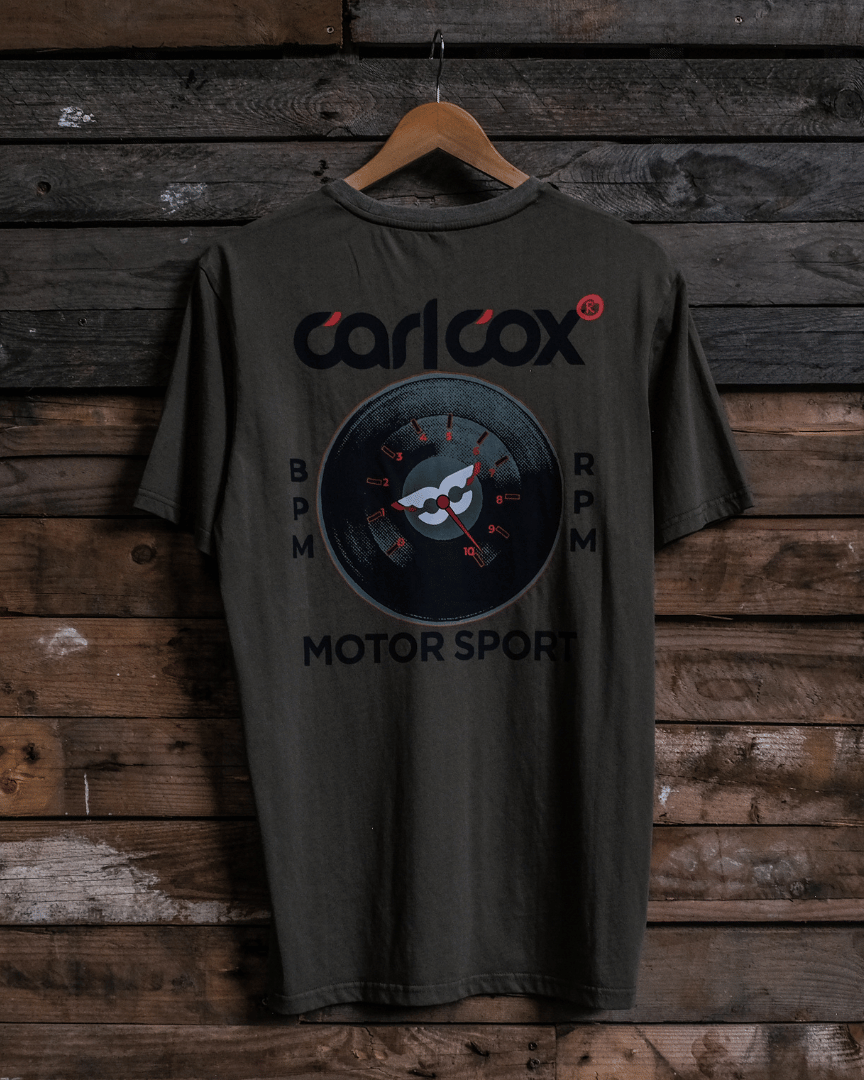 Rear view of a Carl Cox Motorsport BPM RPM green t-shirt on a wooden background