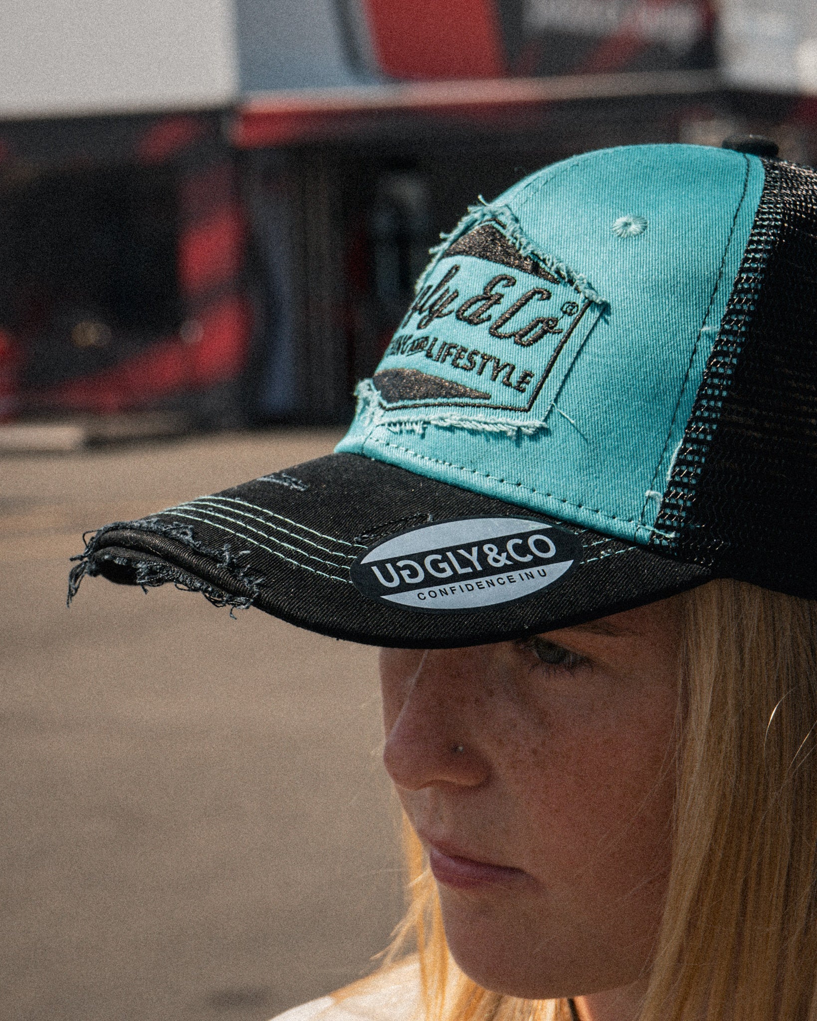 Chloe Jones wearing the turquoise and black Uggly&Co Diamond Trucker Cap
