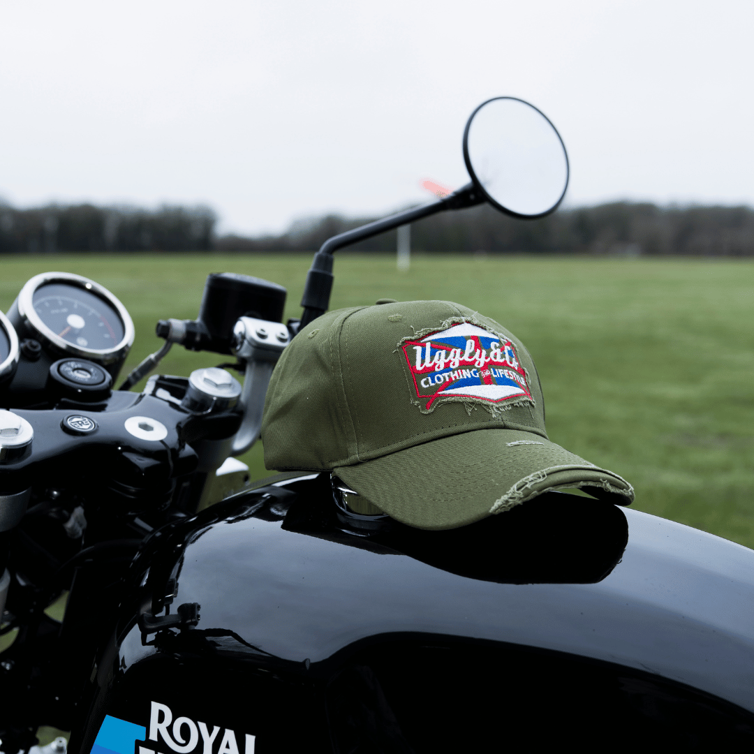Green vintage cap with a union jack Uggly&Co brand logo on a motorcycle fuel tank