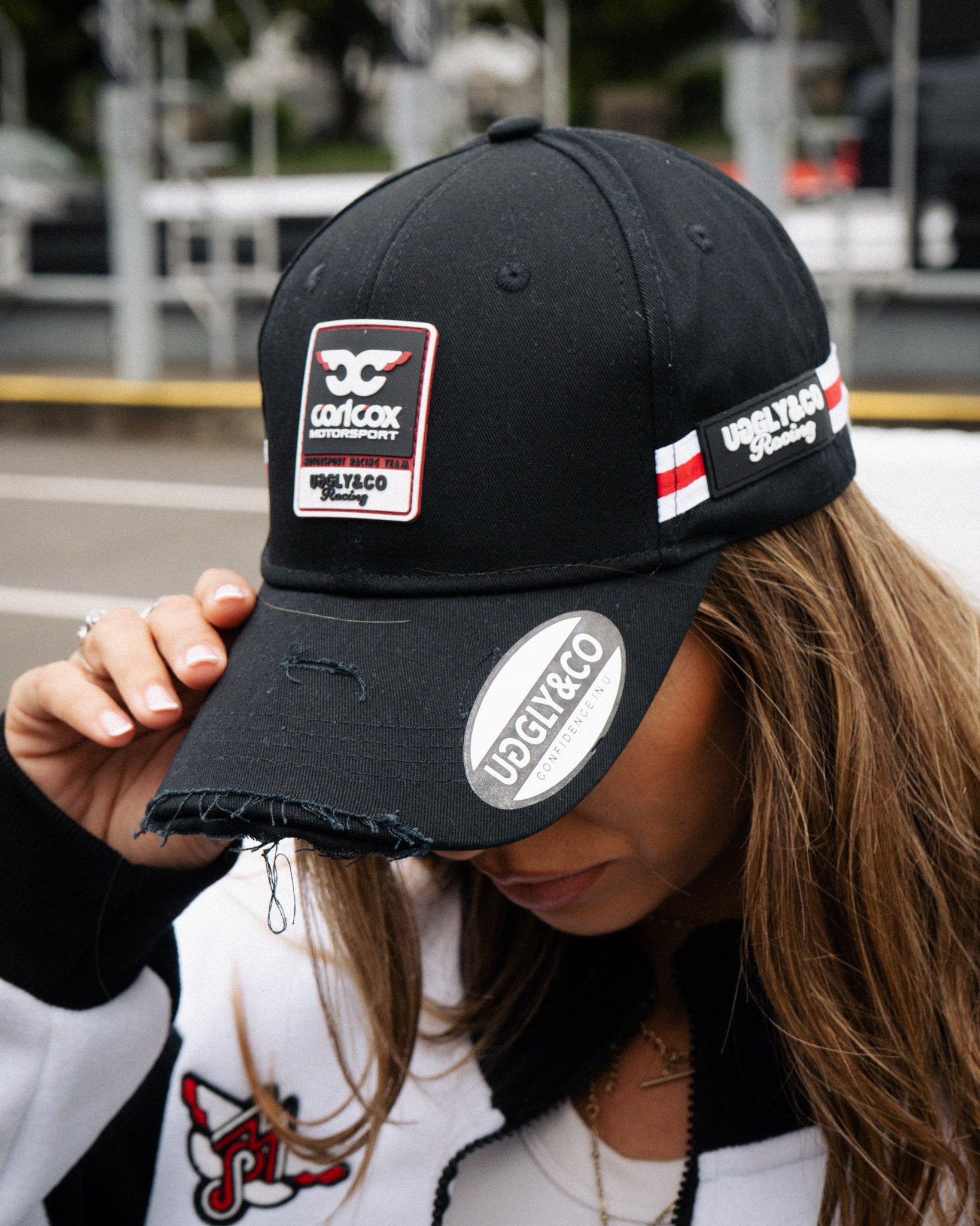 close uo shot of a girl wearing carol cox motorsport cap and track jacket