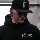 Person wearing a black hoodie with 'Davy Todd' logo and a black cap with a green logo.
