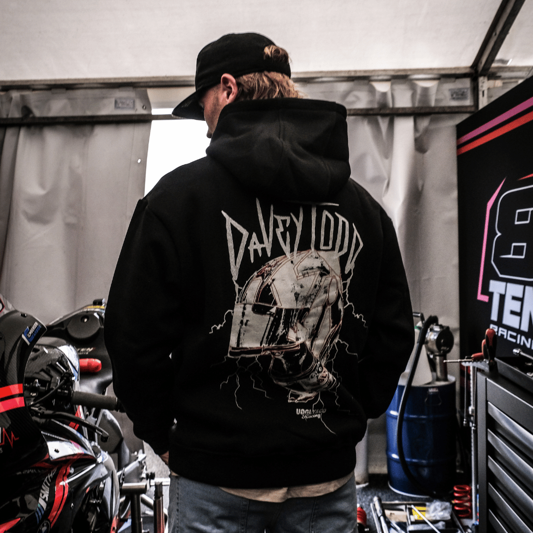 Davey Todd, Road Racer wearing a black hoodie with a graphic design in a garage setting