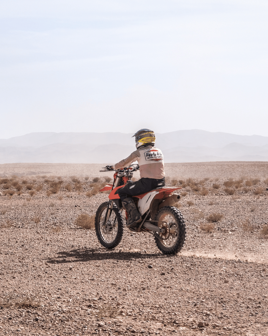 Rider on MX bike in a motocross jersey with 'Uggly & Co Motorcycle Clothing' logo