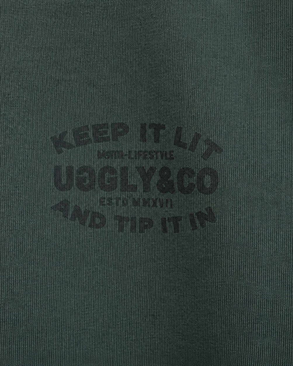 close up product photo of the uggly and co green keep it lit t shirt