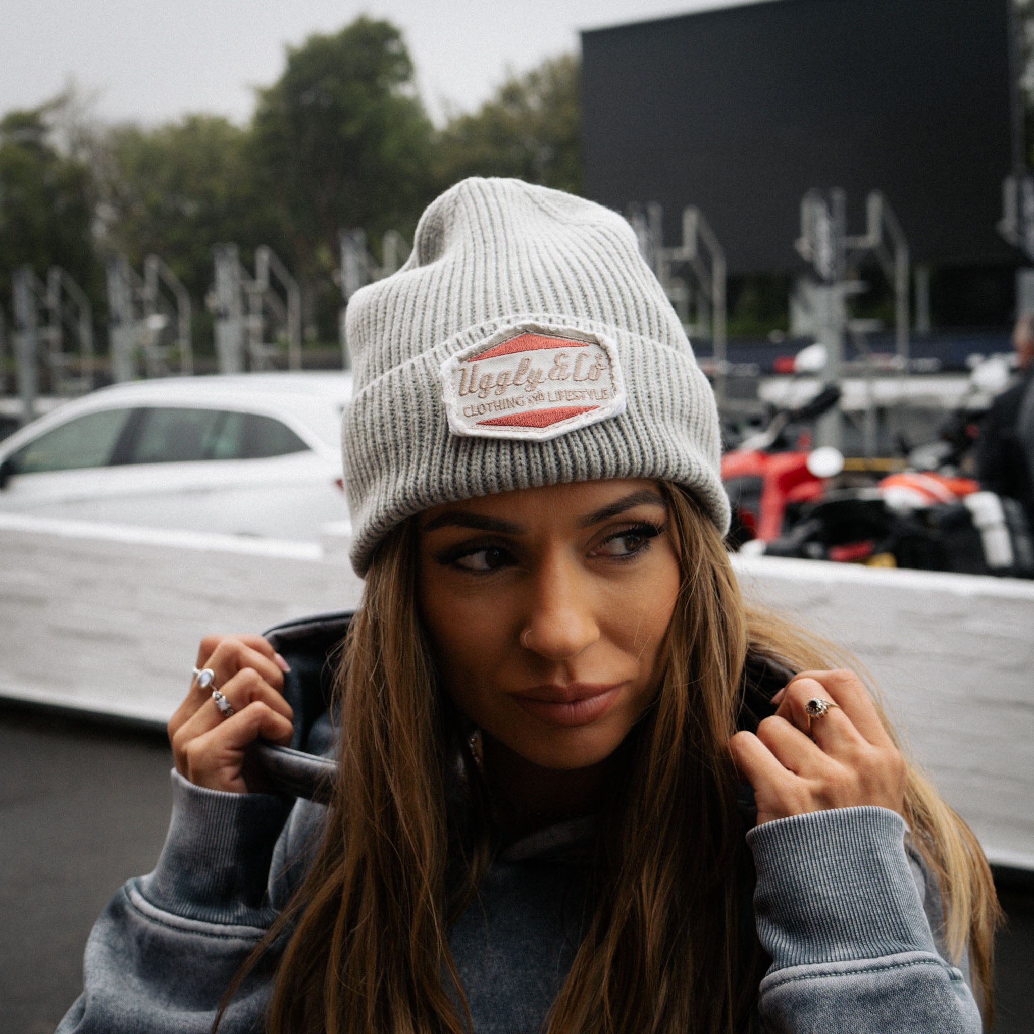 Trackside lifestyle image of a girl model wearing the grey Diamond beanie