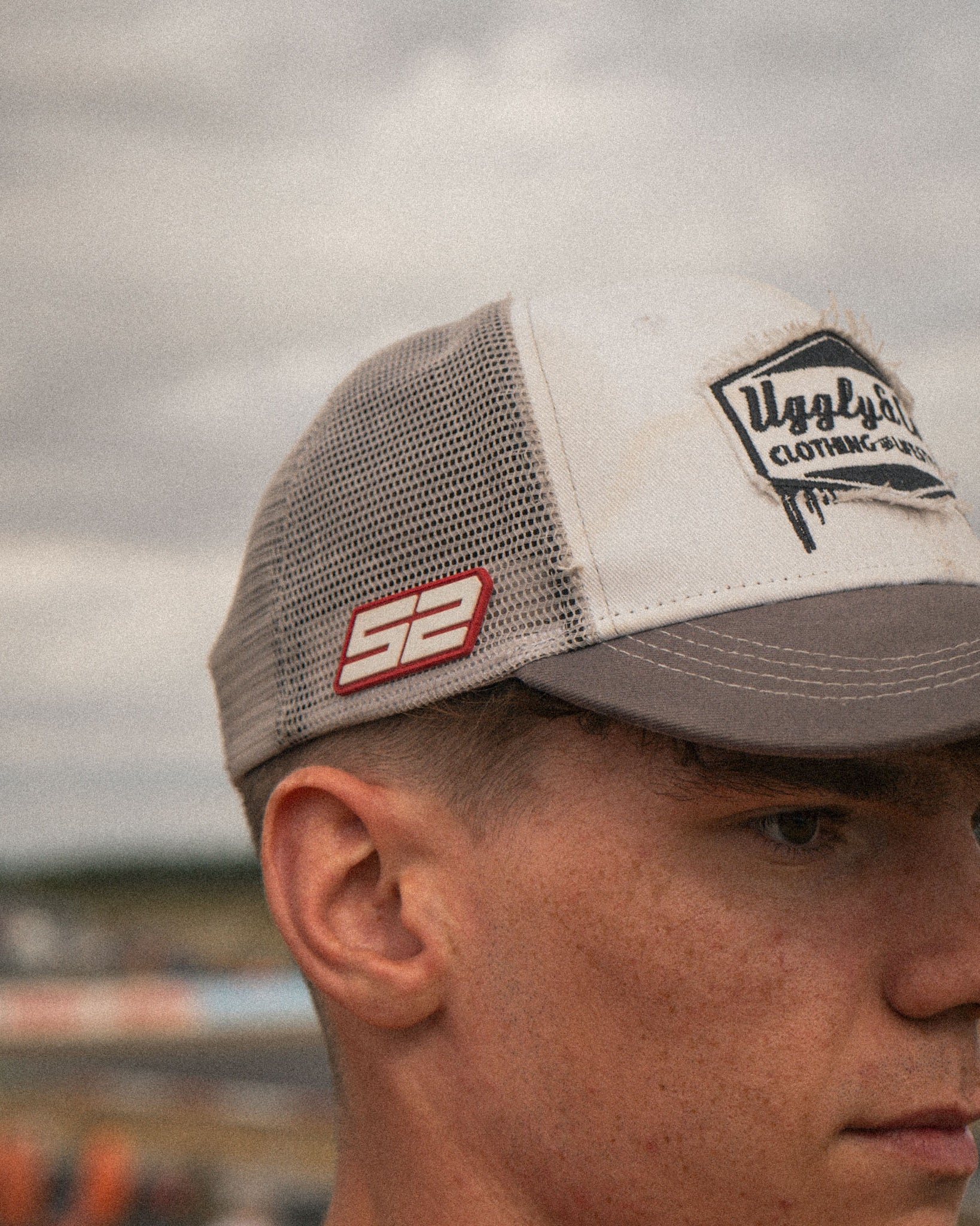 Kam Dixon wearing the grey and white Diamond Trucker Cap with motorsport-inspired styling.