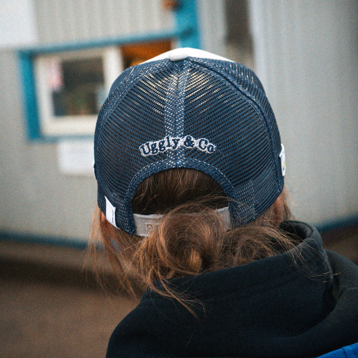 Katie Hand wearing the Uggly&Co Off White and Navy Diamond Trucker Hat