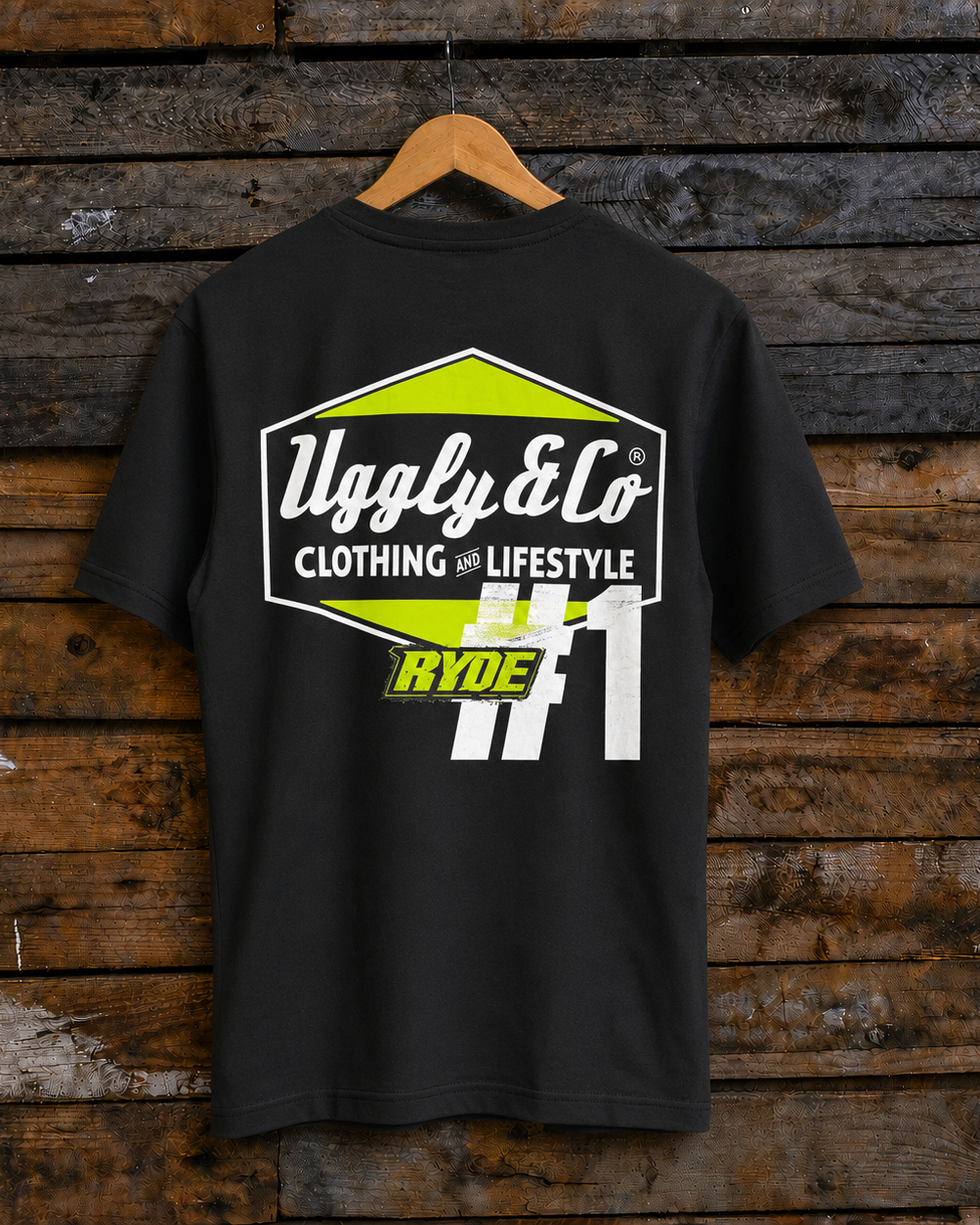 Rear view of an Uggly & Co and Kyle Ryde #1 diamond graphic black t-shirt with white and lime green accents on a wooden background