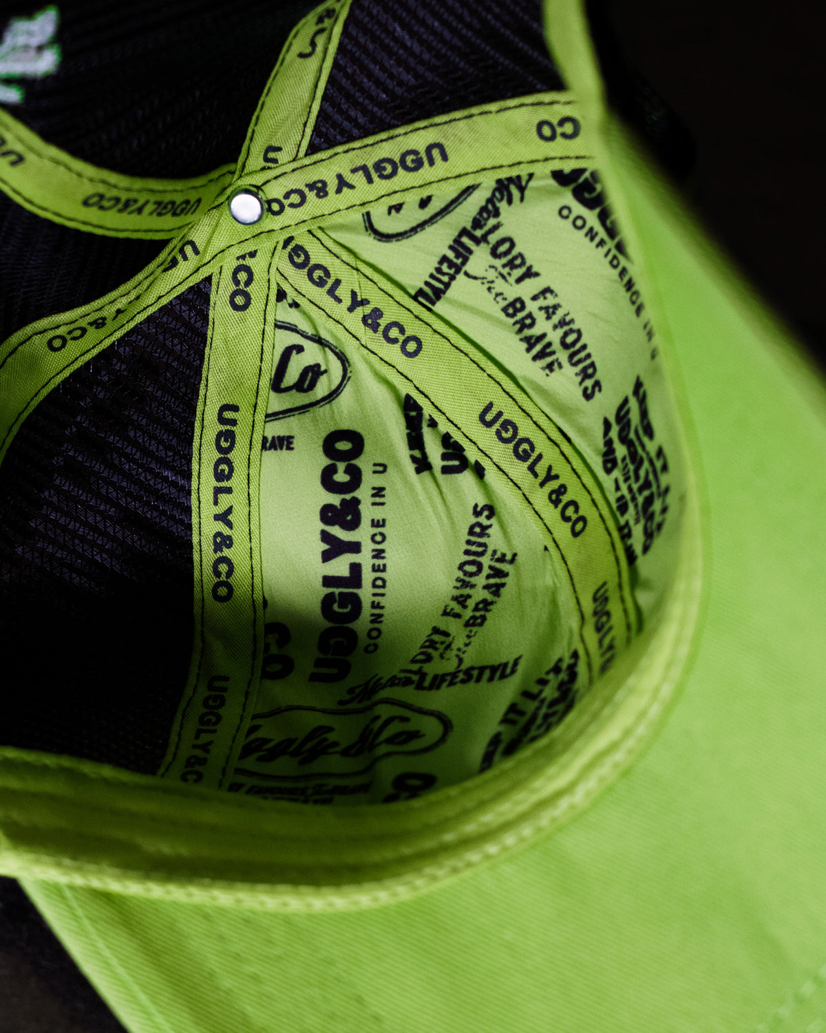 Inside view of the Uggly & Co Fluro Diamond Trucker Hat x Kyle Ryde on a concrete floor, showcasing the inner lining and construction of the British Superbikes cap.