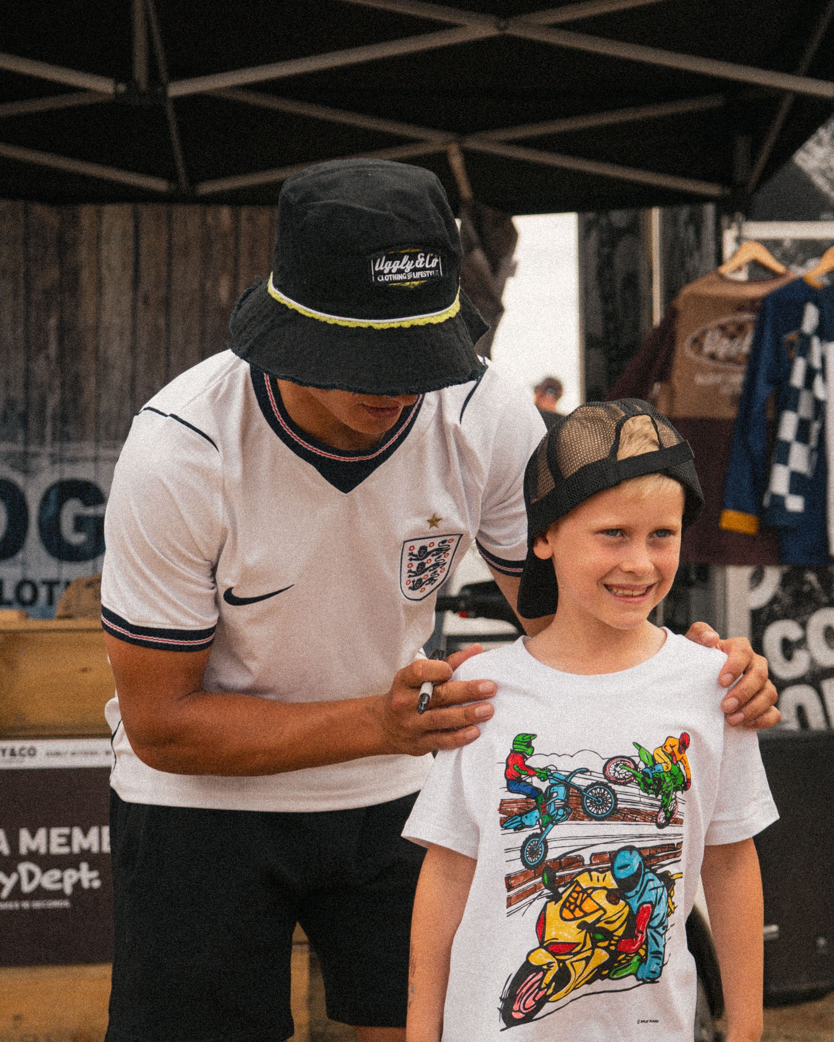 Kyle Ryde in his black bucket hat with young motorsport fan in uggly and co merch