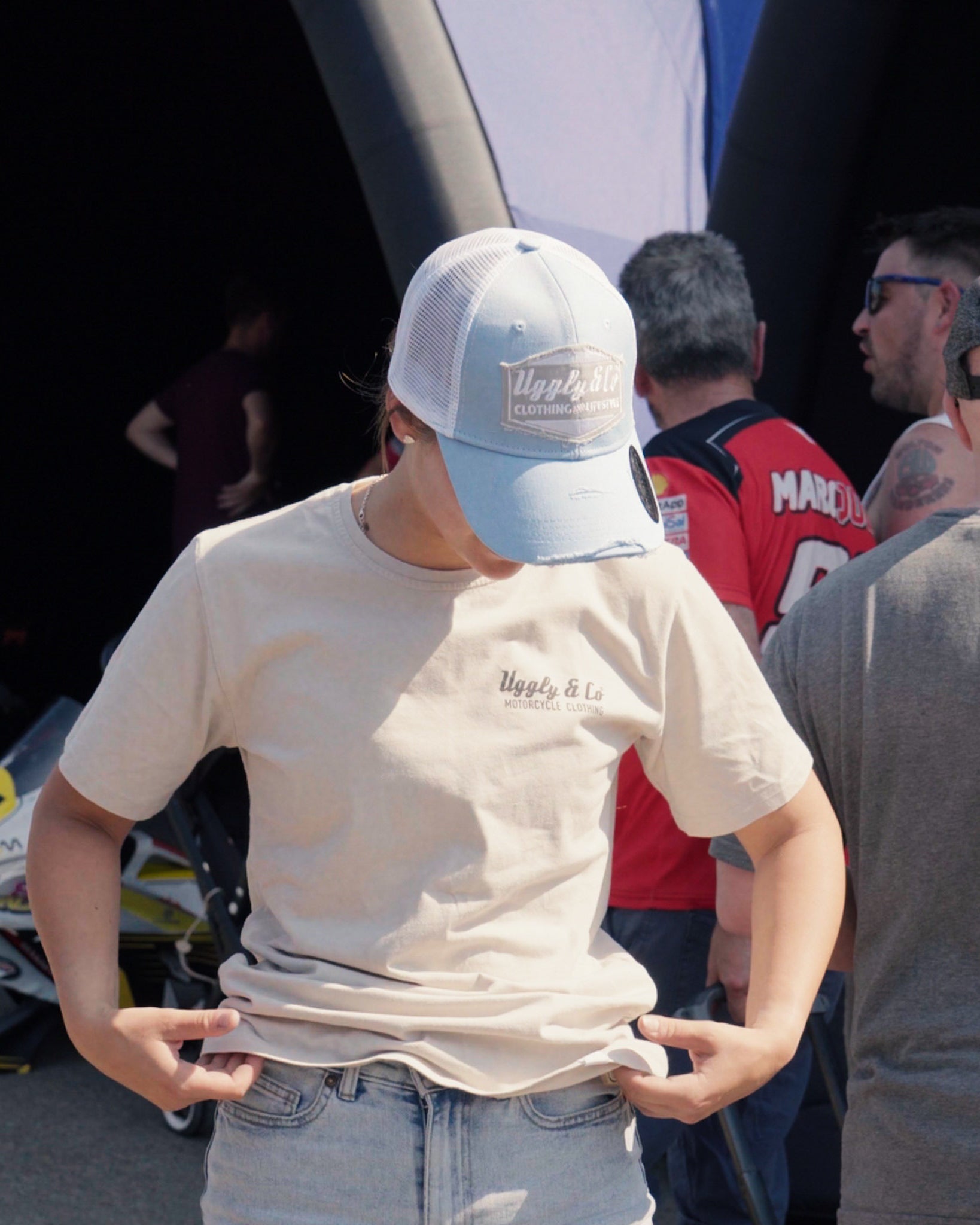 Light blue and silver Diamond trucker hat shown from the front worn by Katie hand