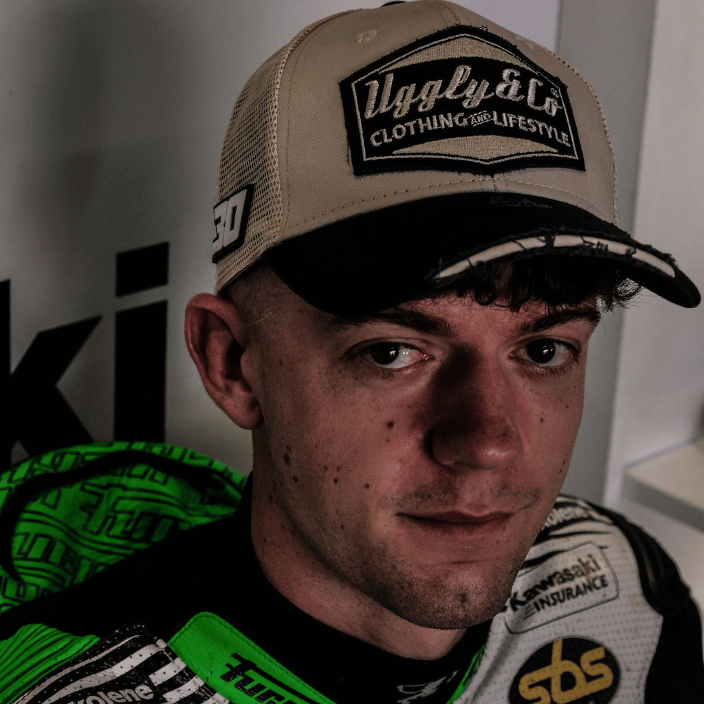 Max Cook wearing a beige cap with an Uggly&Co logo, close up sitting down