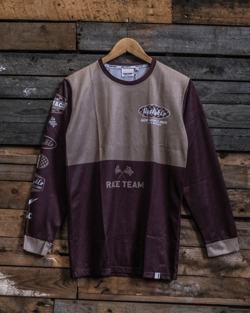 Long-sleeve MX shirt with Uggly&Co logo on a wooden background facing forwards