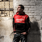A person wearing a Milwaukee Tools x DUCATI hoodie with a red and black color scheme, featuring the DUCATI logo on the chest.