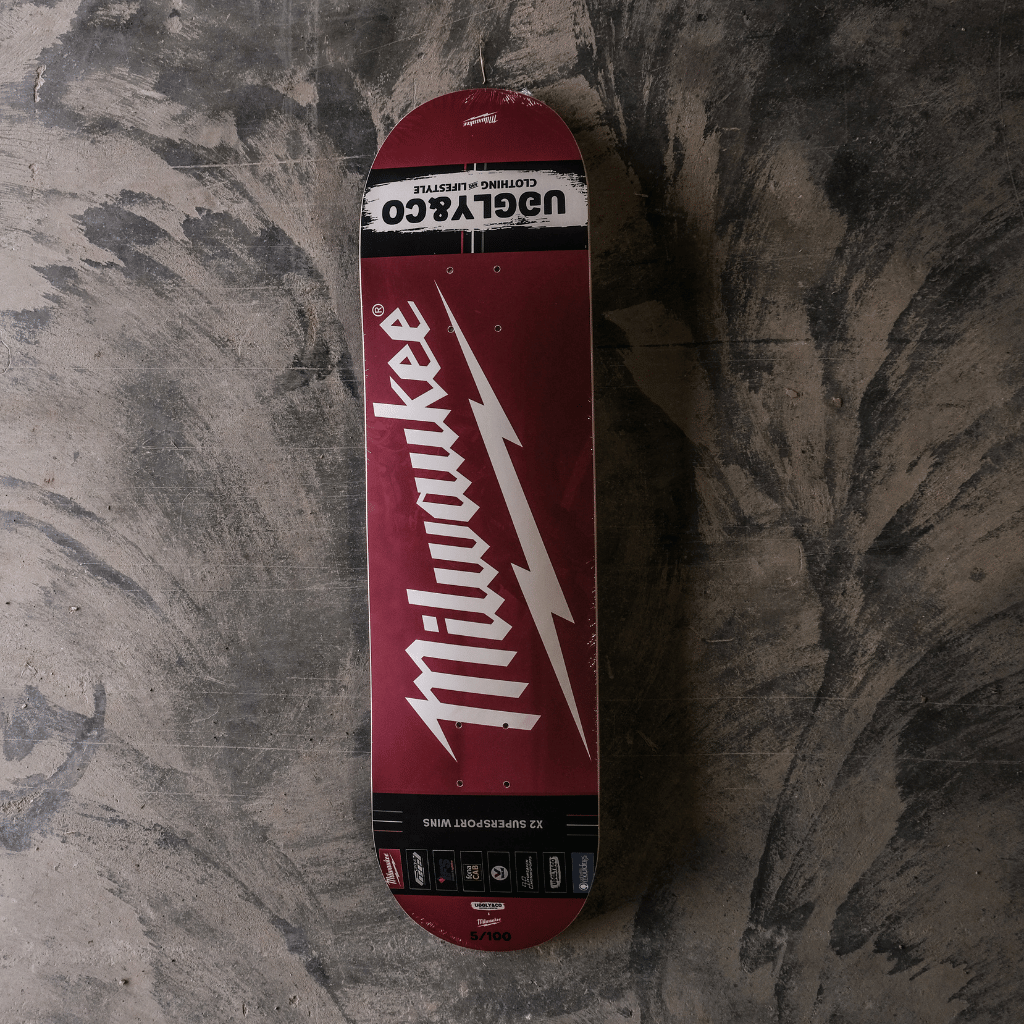 Skateboard deck with Milwaukee logo on a textured surface