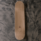 Wooden skateboard deck on a textured gray surface