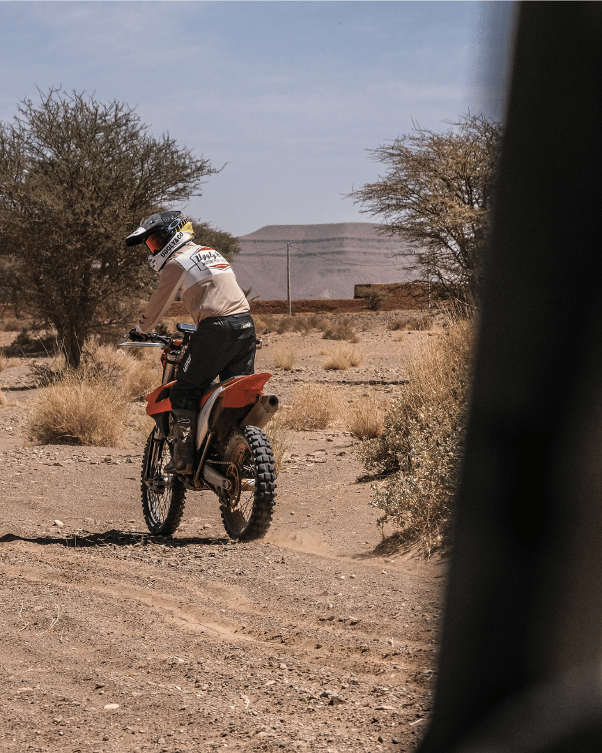 MX rider in the desert in a motocross jersey with 'Uggly & Co Motorcycle Clothing' logo