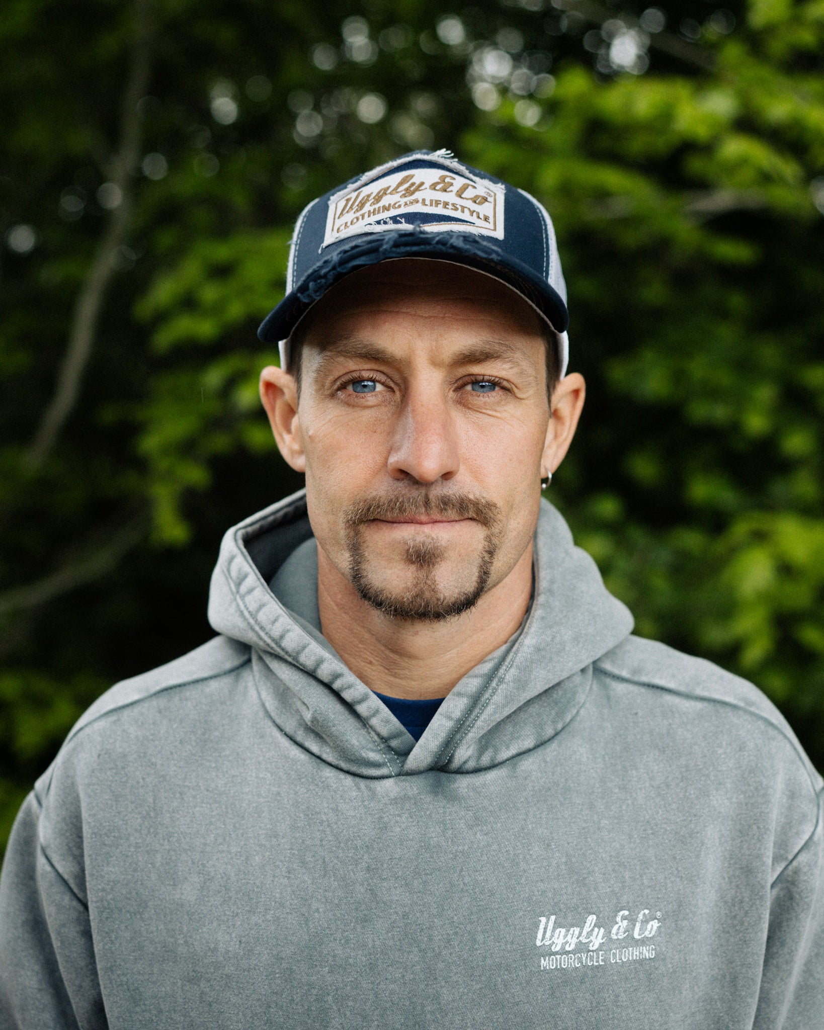 motorbike rider josh Brookes in blue diamond hat stood in front of green plants