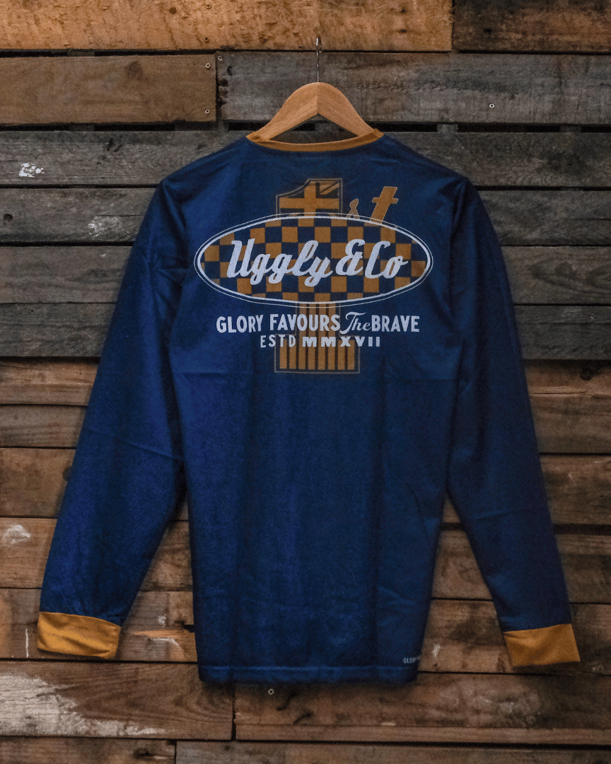 Blue MX shirt with Uggly&Co branding on a wooden background, back side