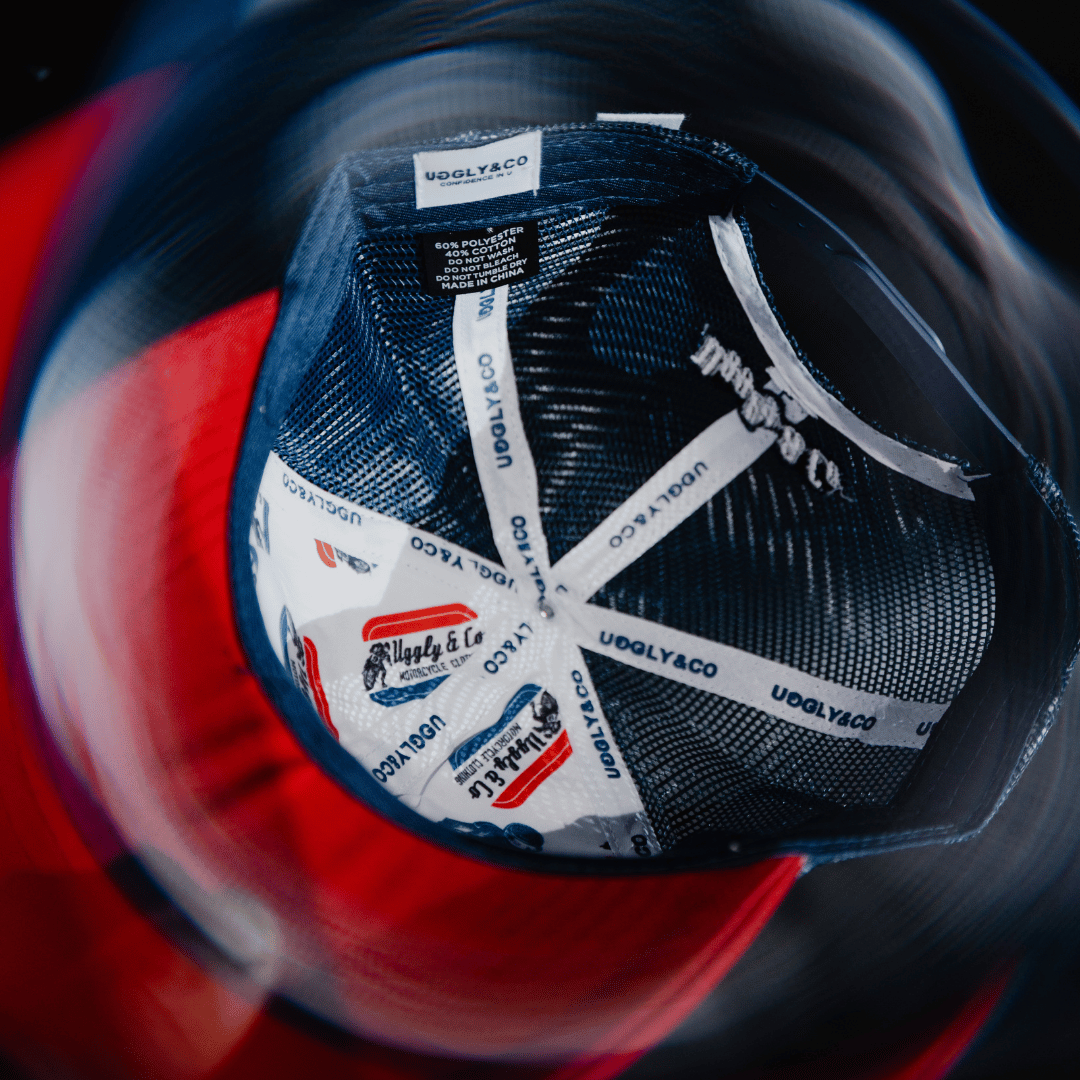 A close up of the inside of a red, white and blue flat-track cap with Uggly&Co branding on the seams