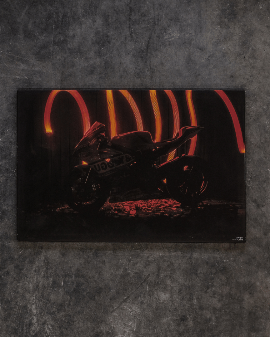 A canvas print featuring the silhouette of a Yamaha R6 motorcycle with red strobe light effects in the background, mounted on a gray wall.