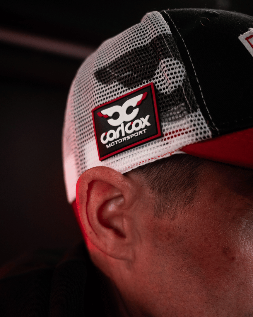 Josh Brookes Isle of man TT Racer wearing a cap with Carl Cox Motorsport logo on a dark background