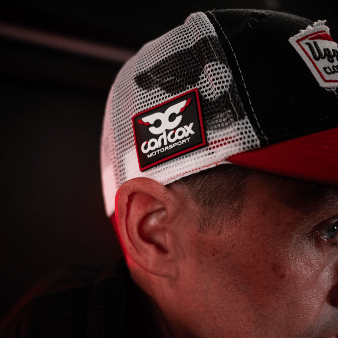 Josh Brookes Isle of man TT Racer wearing a cap with Carl Cox Motorsport logo on a dark background