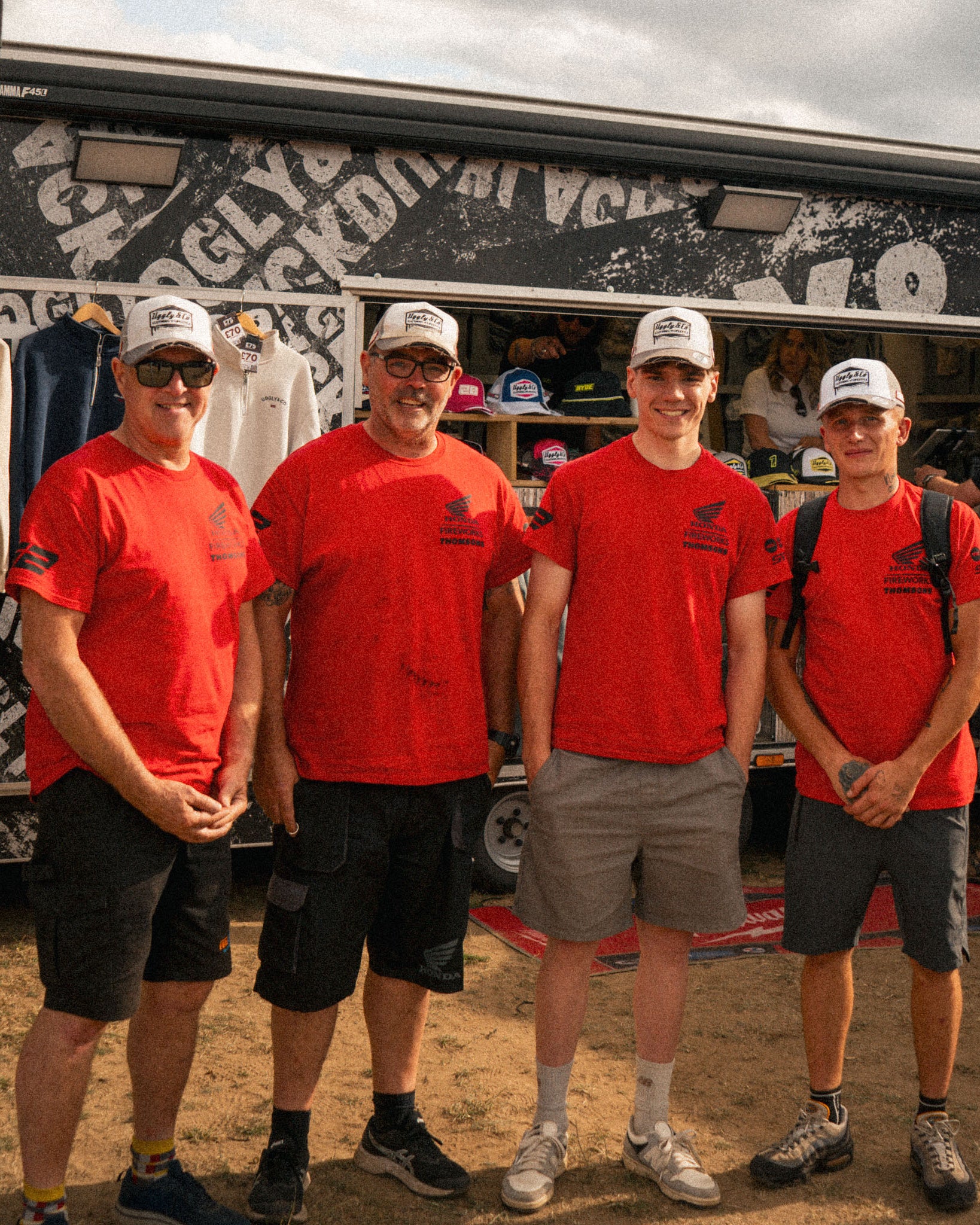race team at motorsport event all wearing white and grey trucker hats