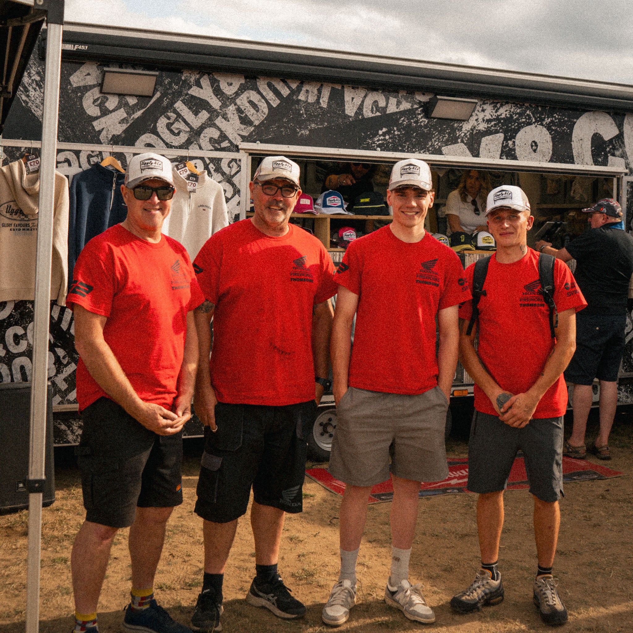 race team at motorsport event all wearing white and grey trucker hats