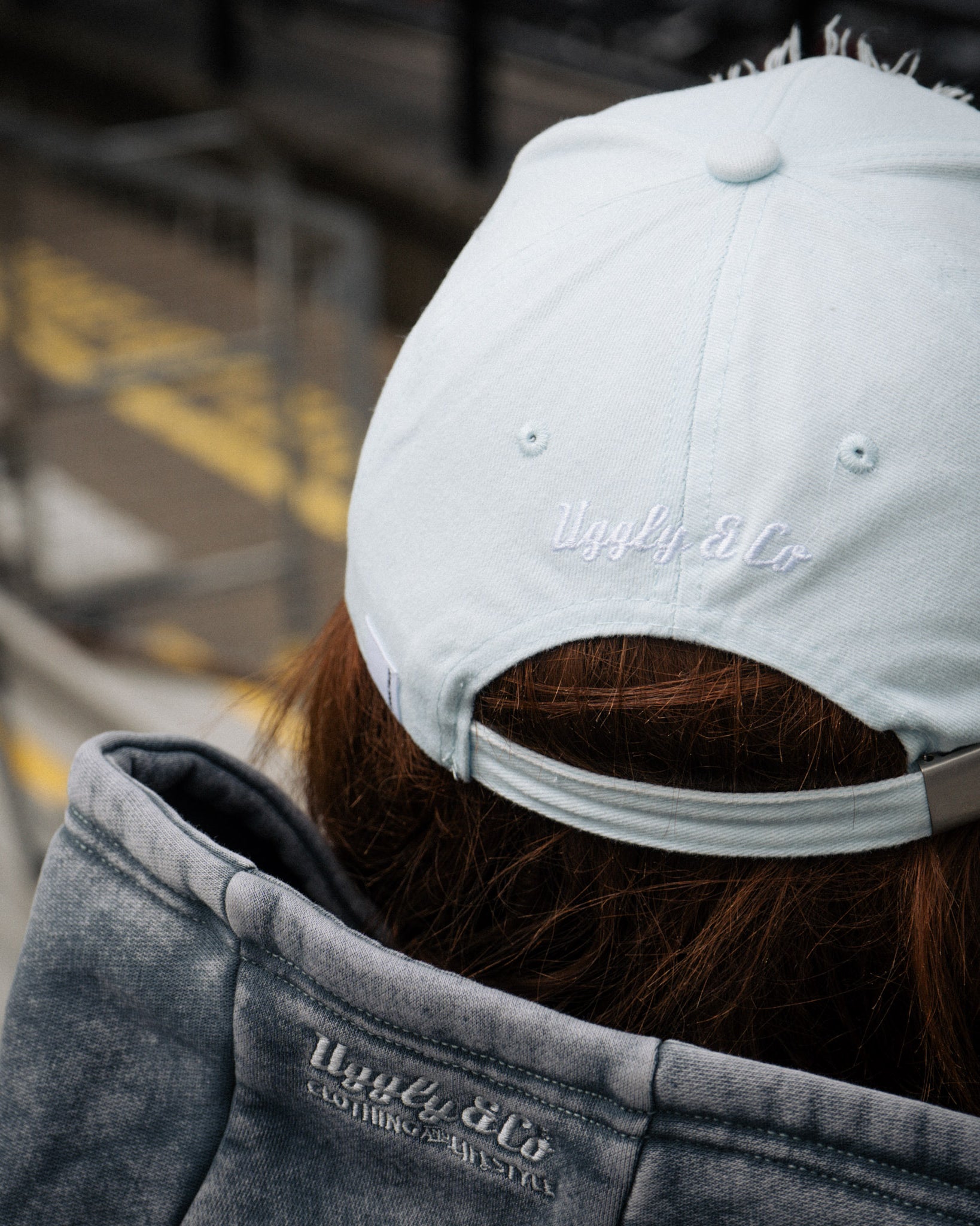 close up rear view shot of a girl wearing a blue cap at a motorsport race