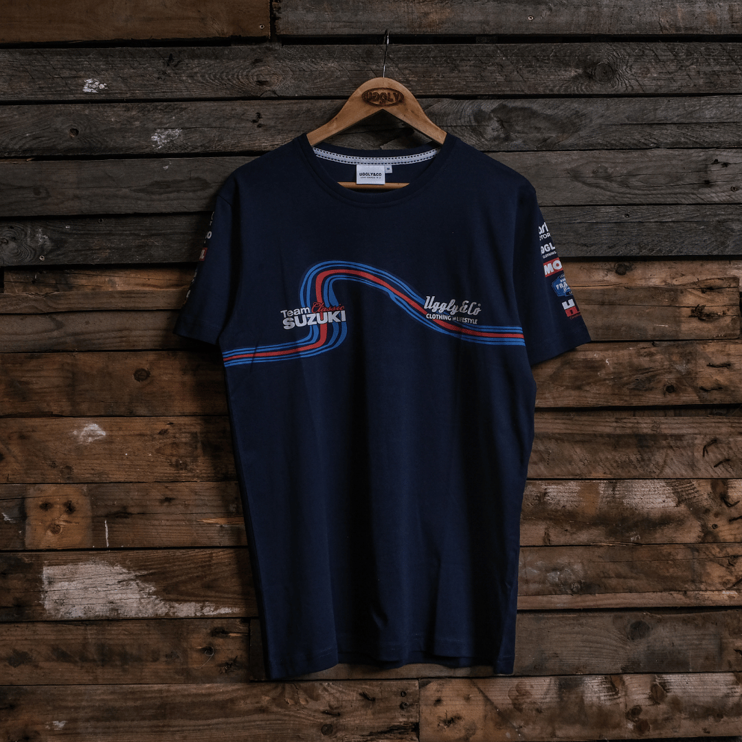 Front view of a navy Team Classic Suzuki blue t-shirt with Uggly&Co branding on a wooden background